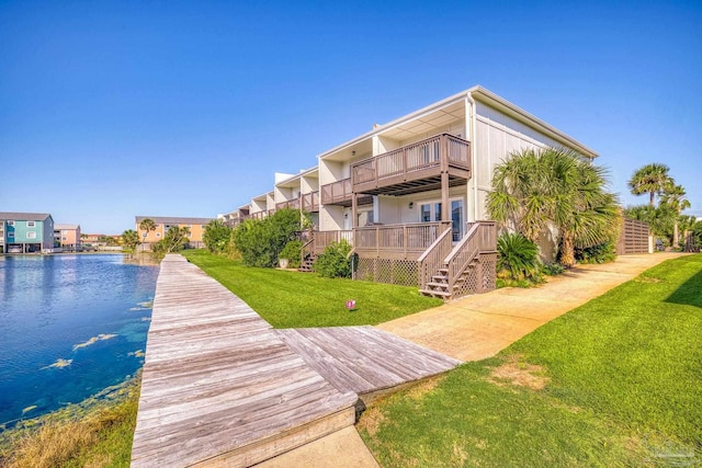 dock area with a lawn and a water view