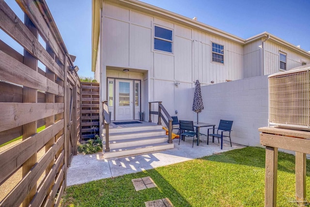 back of property with a lawn and a patio area