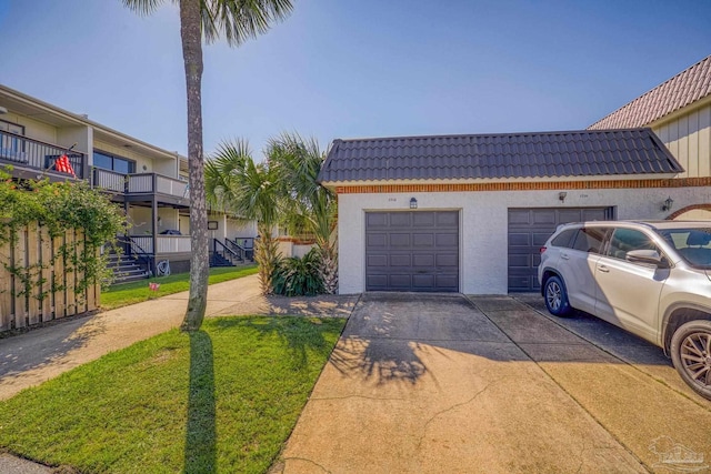 view of home's exterior with a garage, a yard, and a balcony