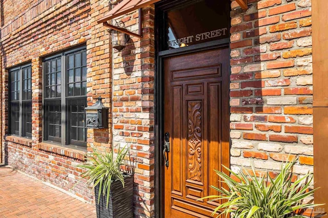 view of exterior entry featuring brick siding