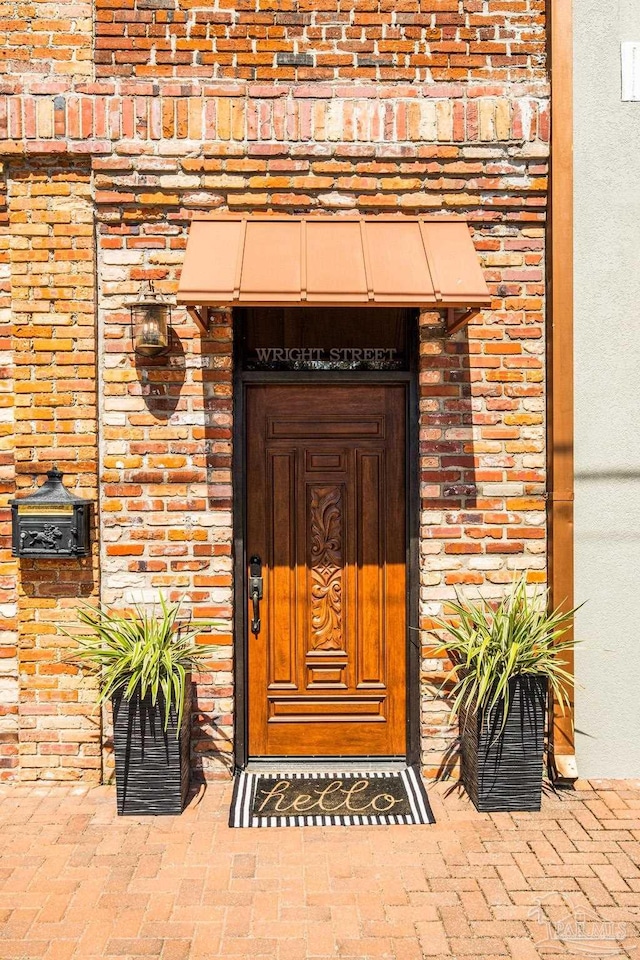 view of exterior entry with brick siding