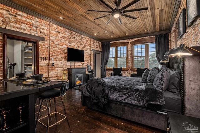 bedroom featuring wood ceiling, wood-type flooring, a wood stove, and brick wall