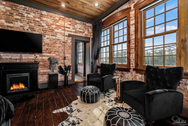 interior space with a warm lit fireplace, wooden ceiling, hardwood / wood-style flooring, brick wall, and crown molding