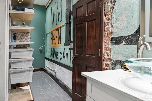 bathroom with a sink, tile patterned flooring, and baseboards