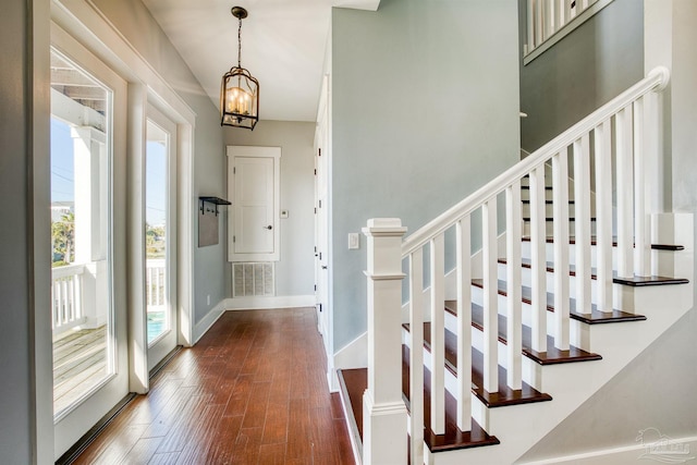 712 Maldonado Dr, Pensacola Beach, FL 32561 - foyer with visible vents, a notable chandelier, dark wood-style floors, baseboards, and stairs