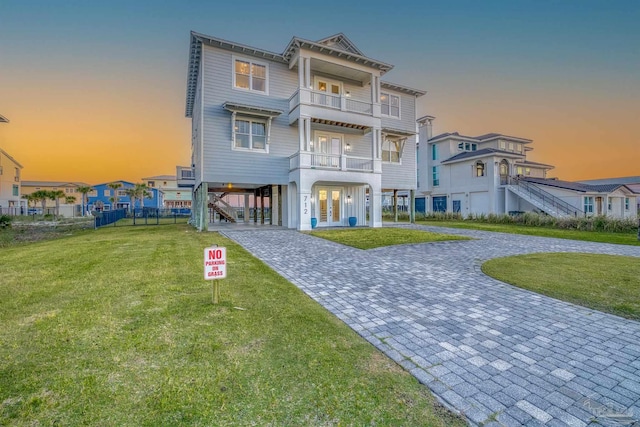 712 Maldonado Dr, Pensacola Beach, FL 32561 - coastal inspired home with decorative driveway, a balcony, french doors, a front yard, and a carport