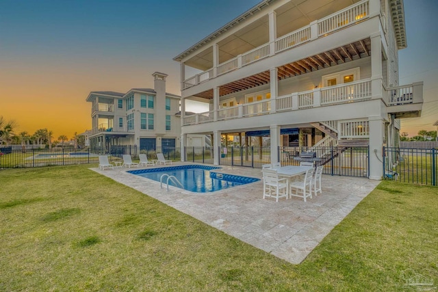 712 Maldonado Dr, Pensacola Beach, FL 32561 - pool at dusk with a patio, a community pool, fence, and a lawn
