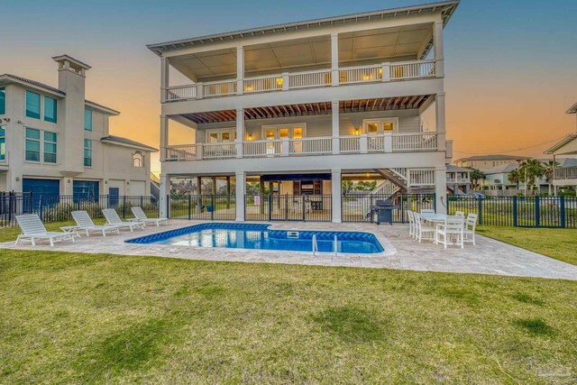 712 Maldonado Dr, Pensacola Beach, FL 32561 - rear view of property with a patio, fence, a yard, a community pool, and stairway