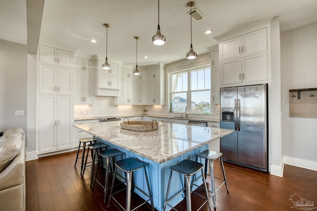 712 Maldonado Dr, Pensacola Beach, FL 32561 - kitchen featuring visible vents, dark wood-type flooring, white cabinets, appliances with stainless steel finishes, and backsplash