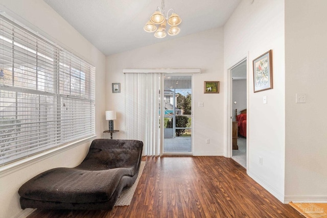 sitting room with dark hardwood / wood-style floors, lofted ceiling, and a chandelier