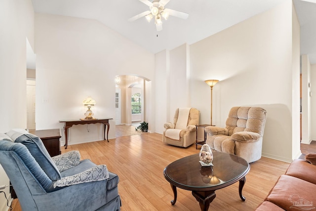 living room featuring ceiling fan, high vaulted ceiling, and light wood-type flooring