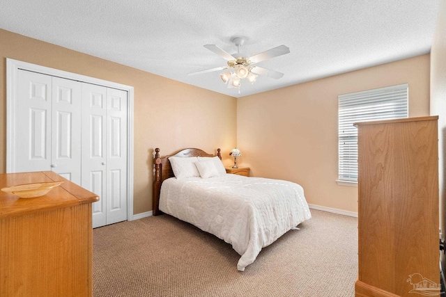 bedroom with ceiling fan, a closet, carpet floors, and a textured ceiling