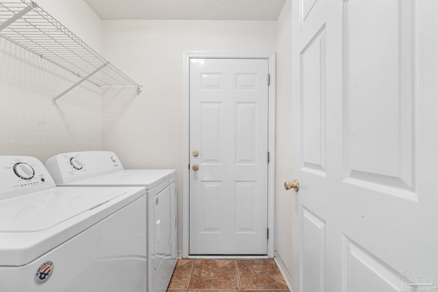 clothes washing area with a textured ceiling and independent washer and dryer