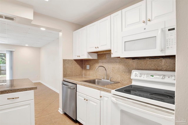 kitchen with sink, light tile patterned floors, backsplash, white appliances, and white cabinets