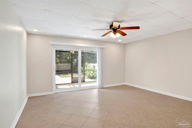 spare room with ceiling fan and a drop ceiling