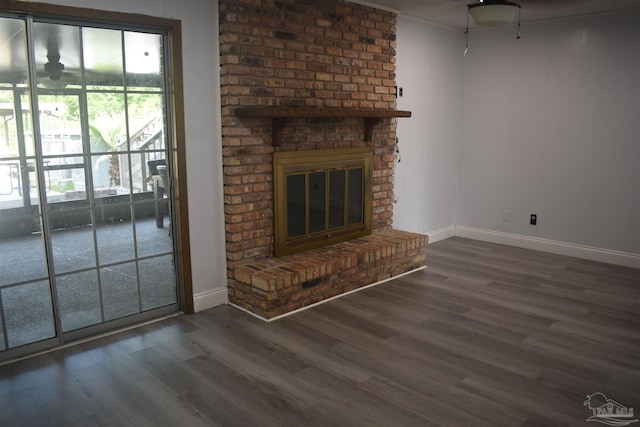 unfurnished living room with a brick fireplace, baseboards, ceiling fan, and wood finished floors