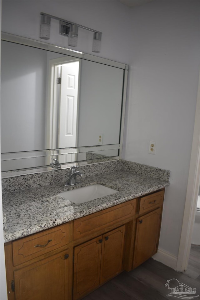bathroom featuring vanity, toilet, and wood finished floors