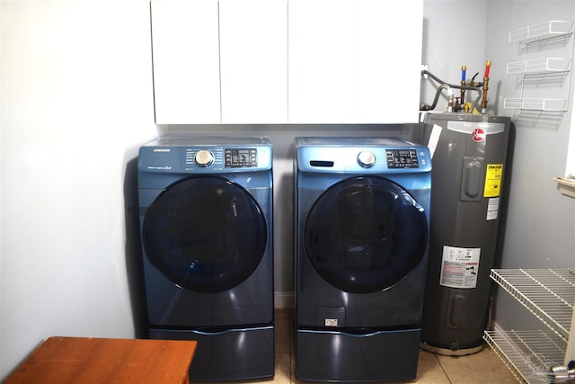 laundry room with light tile patterned floors, washer and clothes dryer, cabinet space, and electric water heater