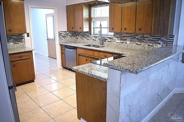 kitchen featuring a sink, light tile patterned floors, decorative backsplash, and a peninsula