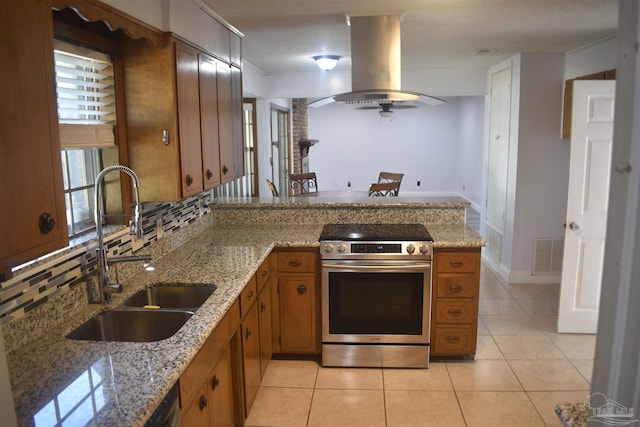kitchen featuring stainless steel electric range, a sink, brown cabinetry, island exhaust hood, and visible vents