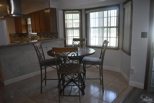 dining room featuring baseboards and light tile patterned floors