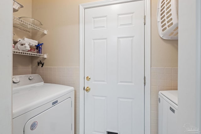 clothes washing area with separate washer and dryer