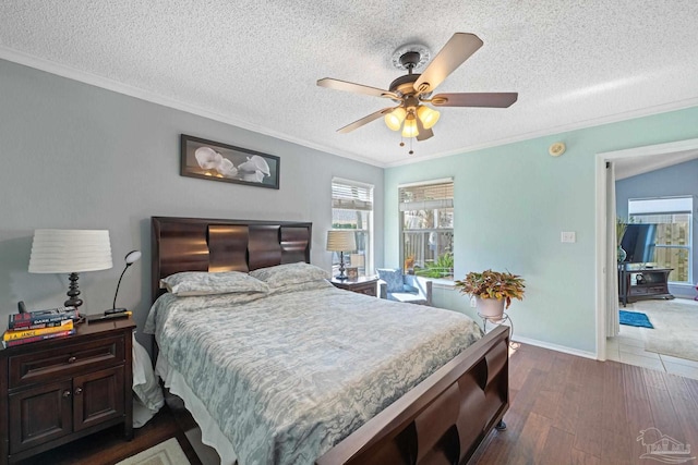 bedroom with ceiling fan, a textured ceiling, dark hardwood / wood-style flooring, and crown molding