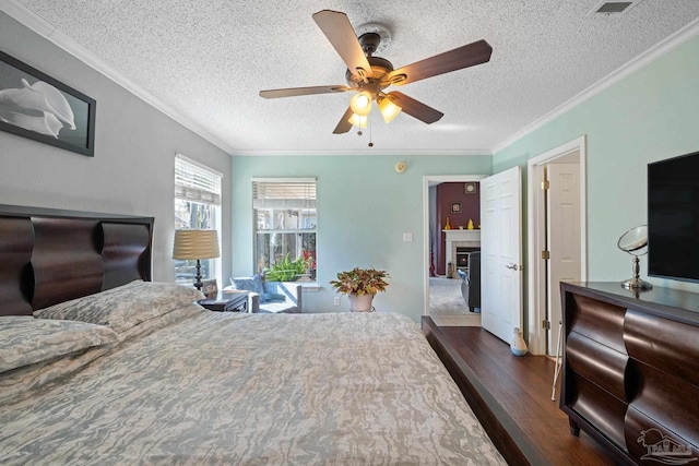 bedroom featuring ceiling fan, dark hardwood / wood-style flooring, ornamental molding, and a textured ceiling