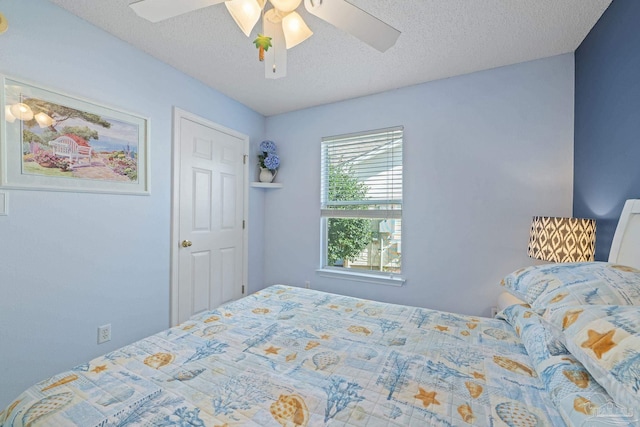 bedroom with ceiling fan and a textured ceiling