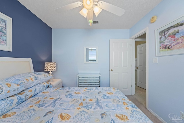 carpeted bedroom featuring a textured ceiling and ceiling fan