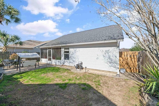 back of property with a patio area, a hot tub, and a lawn