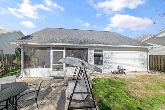 back of property with a patio area, a sunroom, and a lawn