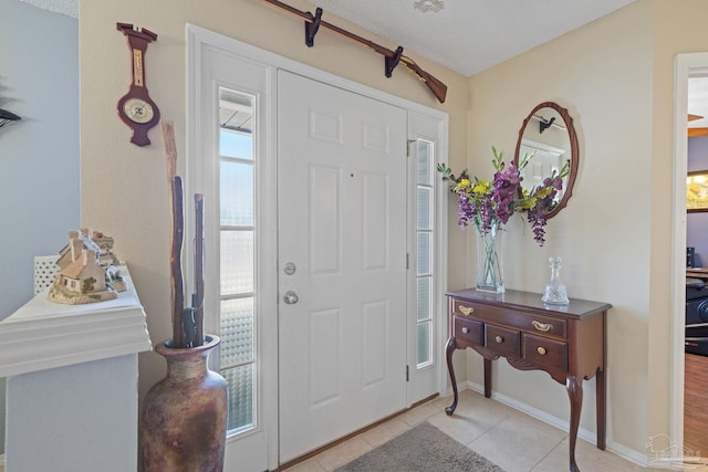 tiled entryway featuring a textured ceiling