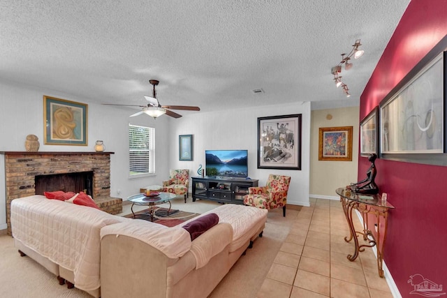 tiled living room with a fireplace, rail lighting, a textured ceiling, and ceiling fan