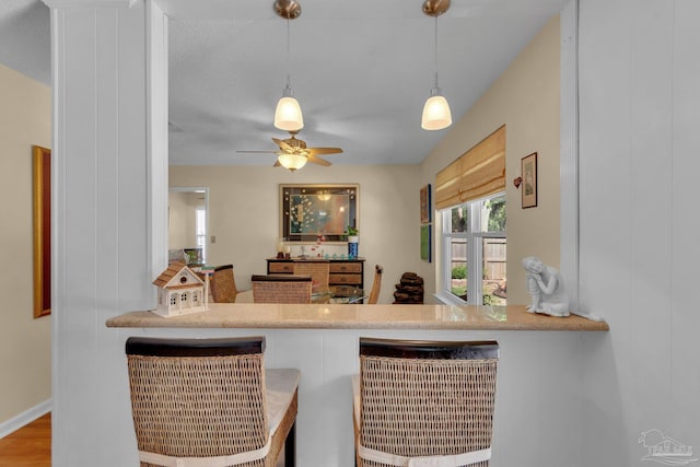 bar featuring hardwood / wood-style floors, ceiling fan, and decorative light fixtures