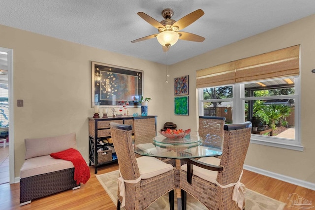 dining room featuring a textured ceiling, hardwood / wood-style flooring, and ceiling fan