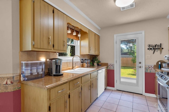 kitchen featuring sink, white dishwasher, a textured ceiling, light tile patterned floors, and stainless steel stove