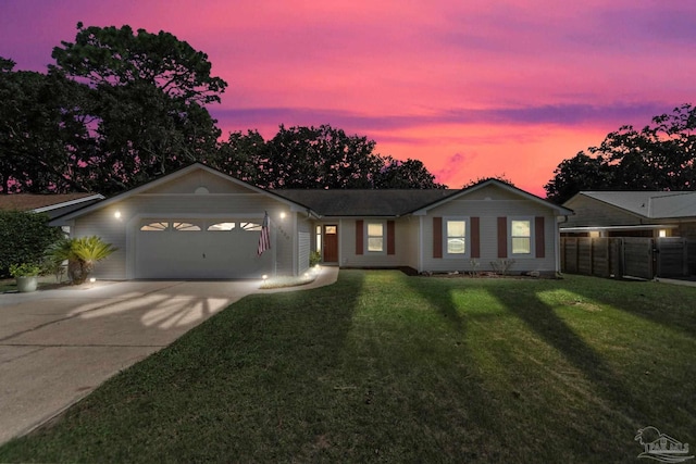 ranch-style home with a garage and a yard