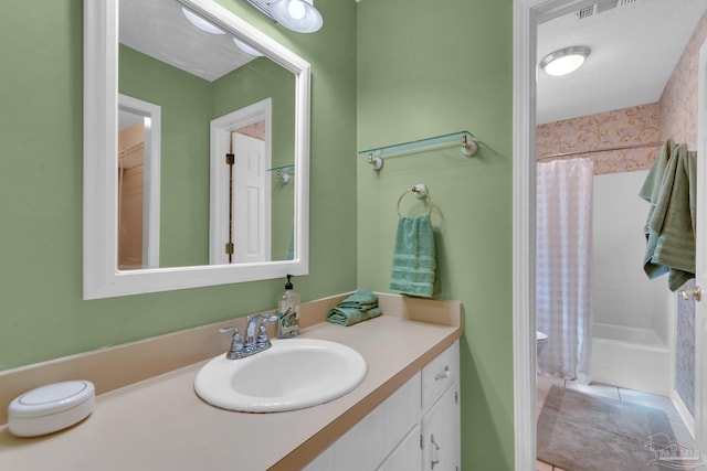 bathroom with shower / tub combo, vanity, a textured ceiling, and tile patterned floors