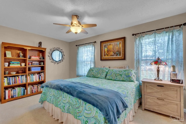 bedroom featuring a textured ceiling, carpet, multiple windows, and ceiling fan