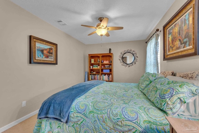 carpeted bedroom with a textured ceiling and ceiling fan