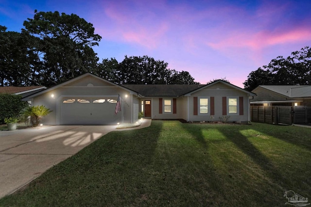 ranch-style home with a garage and a yard