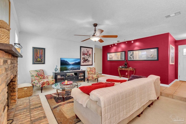 living room featuring light carpet, ceiling fan, a textured ceiling, and a stone fireplace