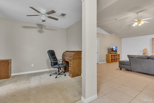 carpeted office space featuring ceiling fan, vaulted ceiling, and a textured ceiling