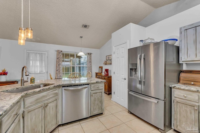 kitchen with a textured ceiling, stainless steel appliances, sink, vaulted ceiling, and light tile patterned floors