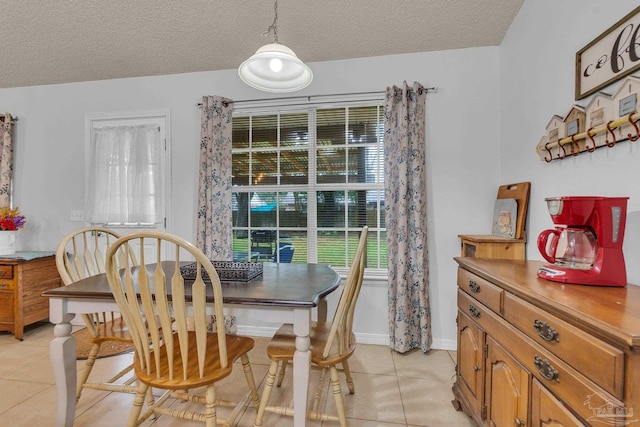 tiled dining room with a textured ceiling