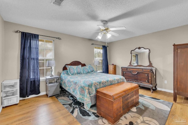 bedroom featuring a textured ceiling, ceiling fan, and wood-type flooring