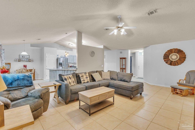 tiled living room with lofted ceiling, ceiling fan, and a textured ceiling