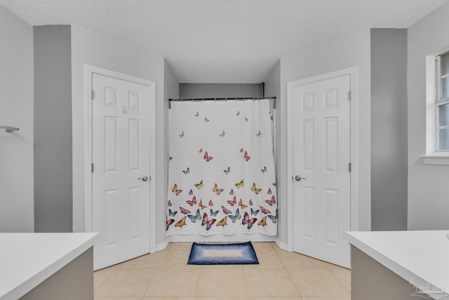 bathroom featuring shower / bath combination with curtain, a textured ceiling, and tile patterned flooring