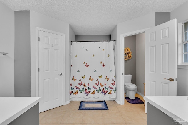 full bathroom featuring a textured ceiling, toilet, and vanity